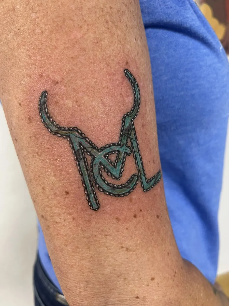 Cattle brand "MCL" with horns — turquoise color, bicep