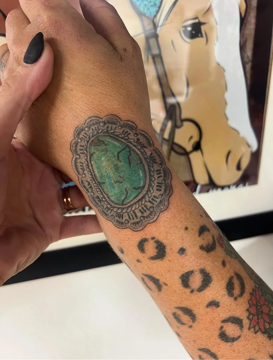 Western concho with turquoise stone on the hand