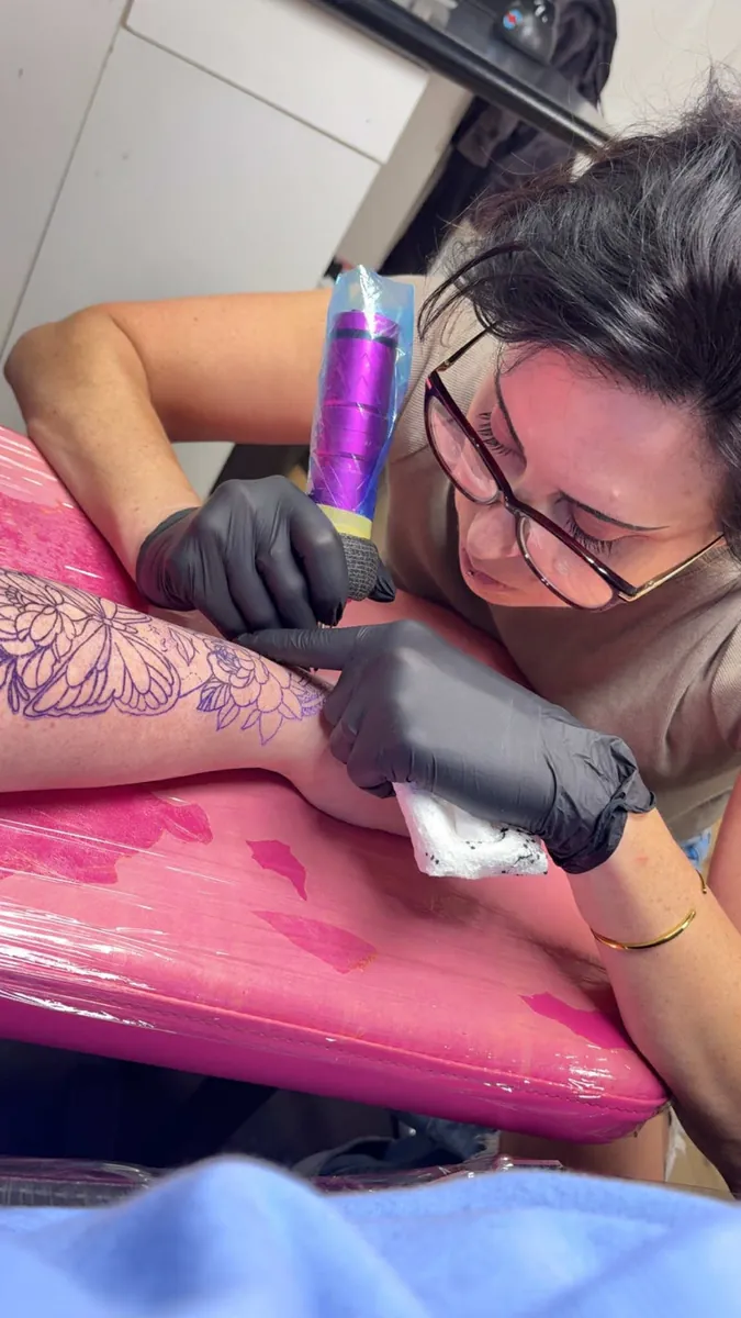 Sabrina at work — peony tattoo on the leg