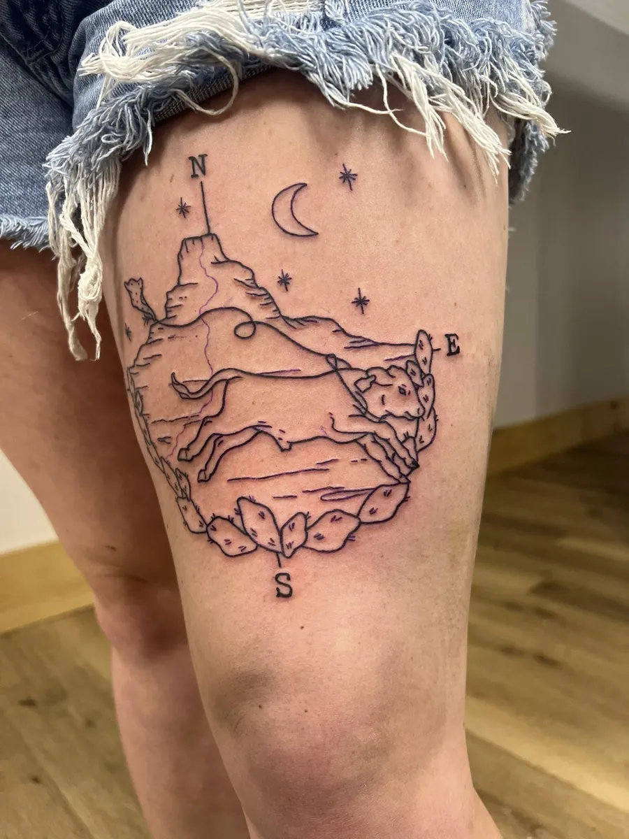 Western linework — running dog, mountain, cactus, compass on thigh